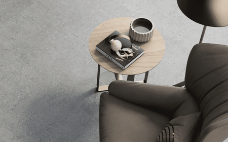 Moderná dlažba v sivej farbe s kreslom v obývačke